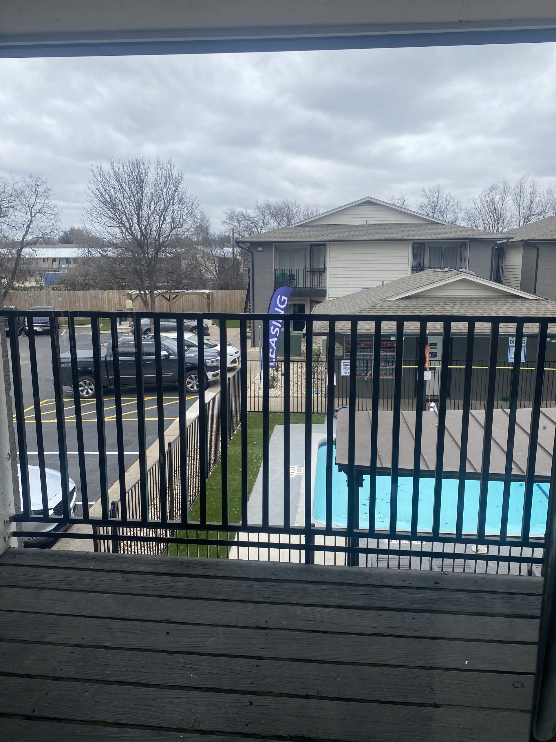 a balcony with a pool and a fence at The Colony Creek Apartments
