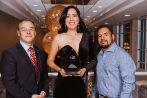 three people posing for a photo with an award at The Colony Creek Apartments