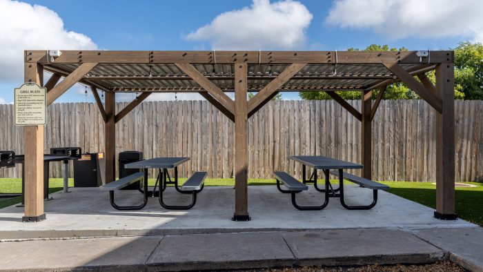 a picnic table under a pergolied roof at The Colony Creek Apartments