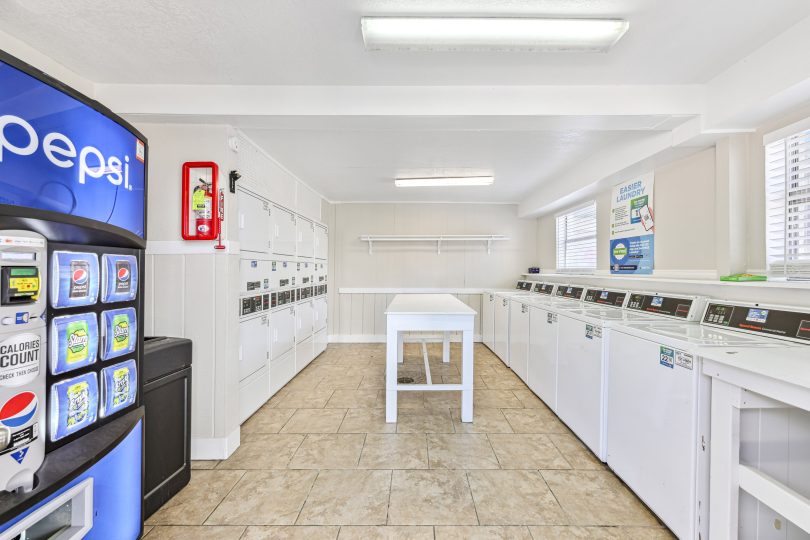 a laundry room with a vending machine and a washer at The Canyon Creek Apartments