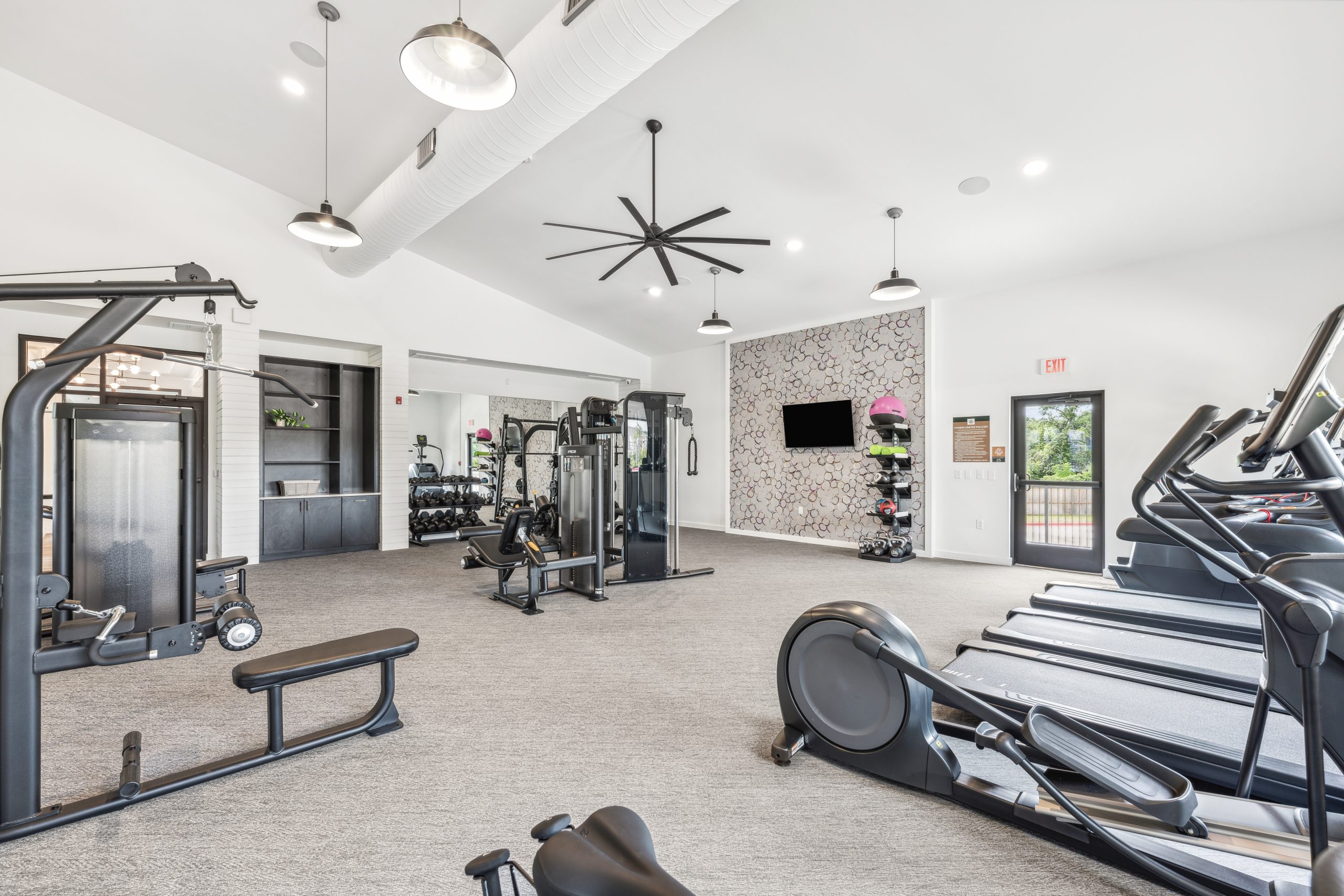 a gym room with tread machines and a ceiling fan at The Rushcreek
