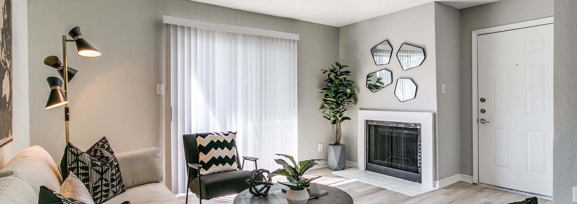 a living room with a fireplace and white furniture at The Falltree Apartments