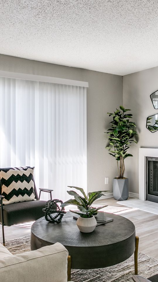 a living room with a fireplace and white furniture at The Falltree Apartments