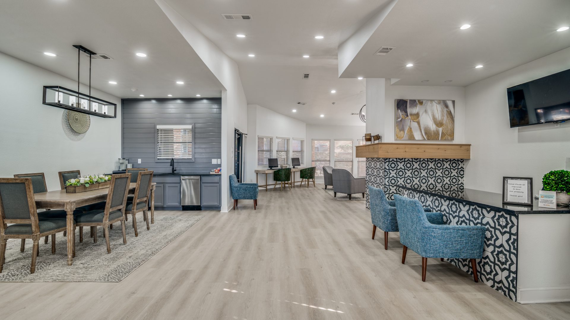 the lobby of a modern apartment building with blue chairs at The Falltree Apartments