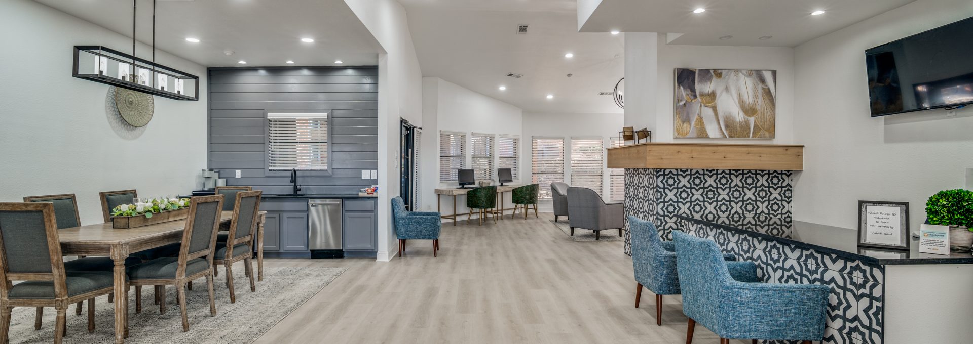 the lobby of a modern apartment building with blue chairs at The Falltree Apartments