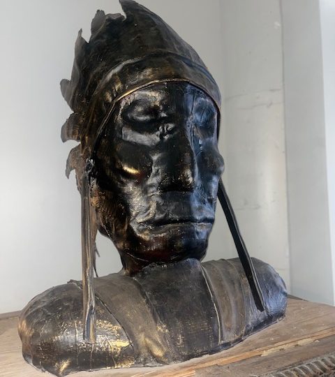 a statue of a man sitting on top of a table
