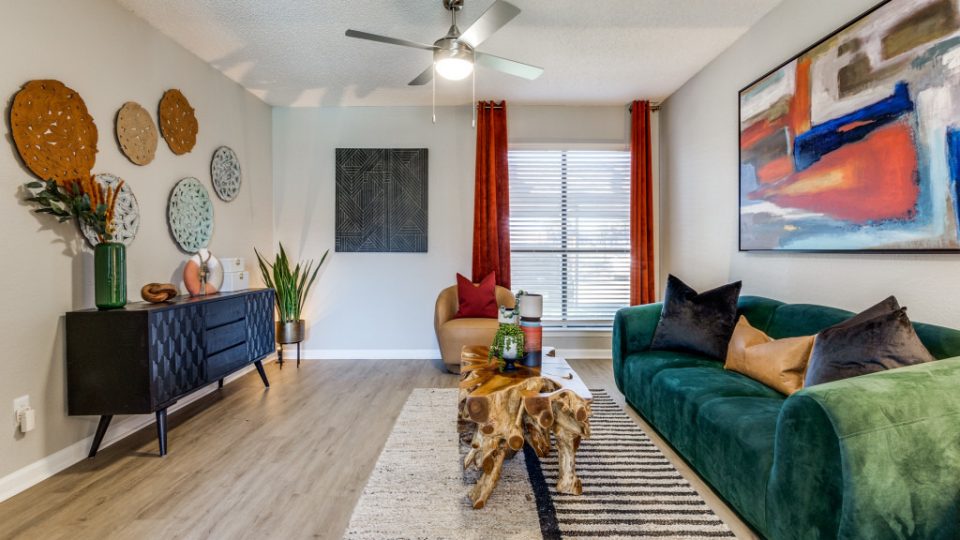a living room with a green couch and a painting on the wall at The  Reid Apartments