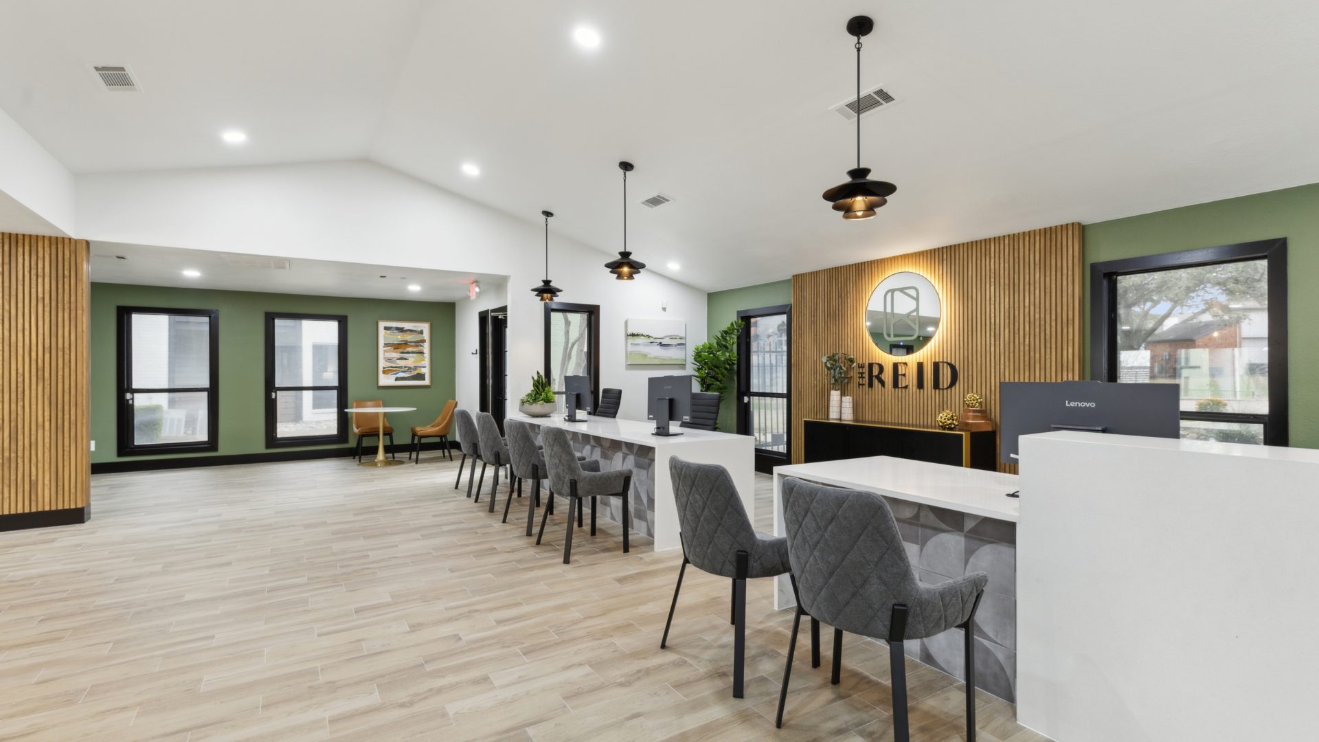 the lobby of a new apartment building with green walls and wood floors at The  Reid Apartments
