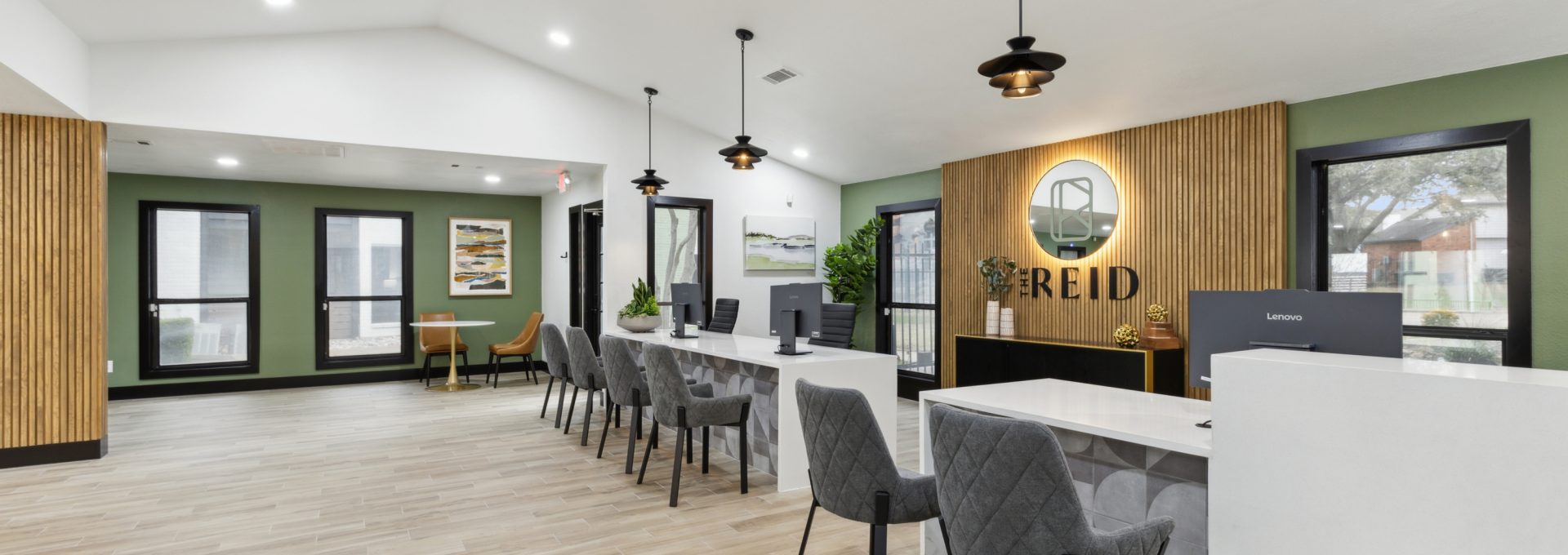 the lobby of a new apartment building with green walls and wood floors at The  Reid Apartments