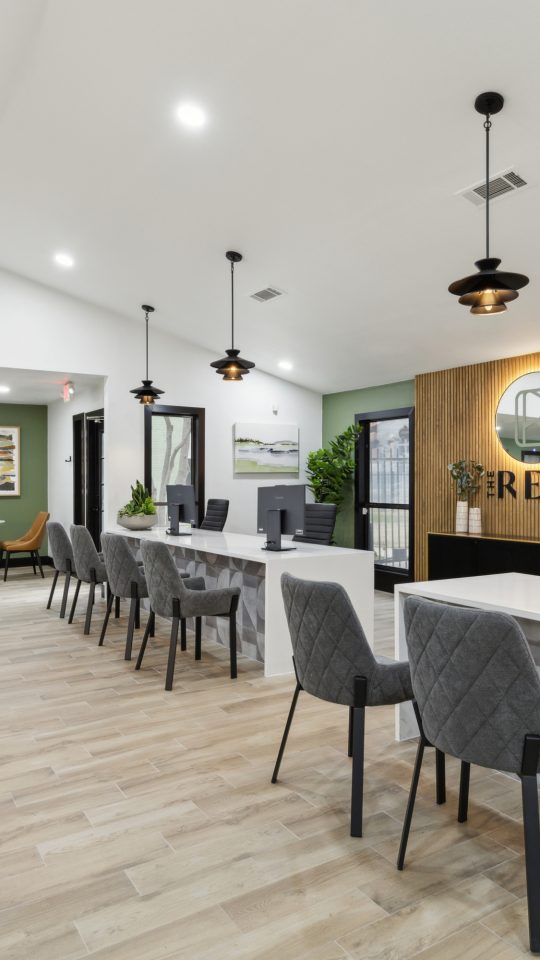 the lobby of a new apartment building with green walls and wood floors at The  Reid Apartments