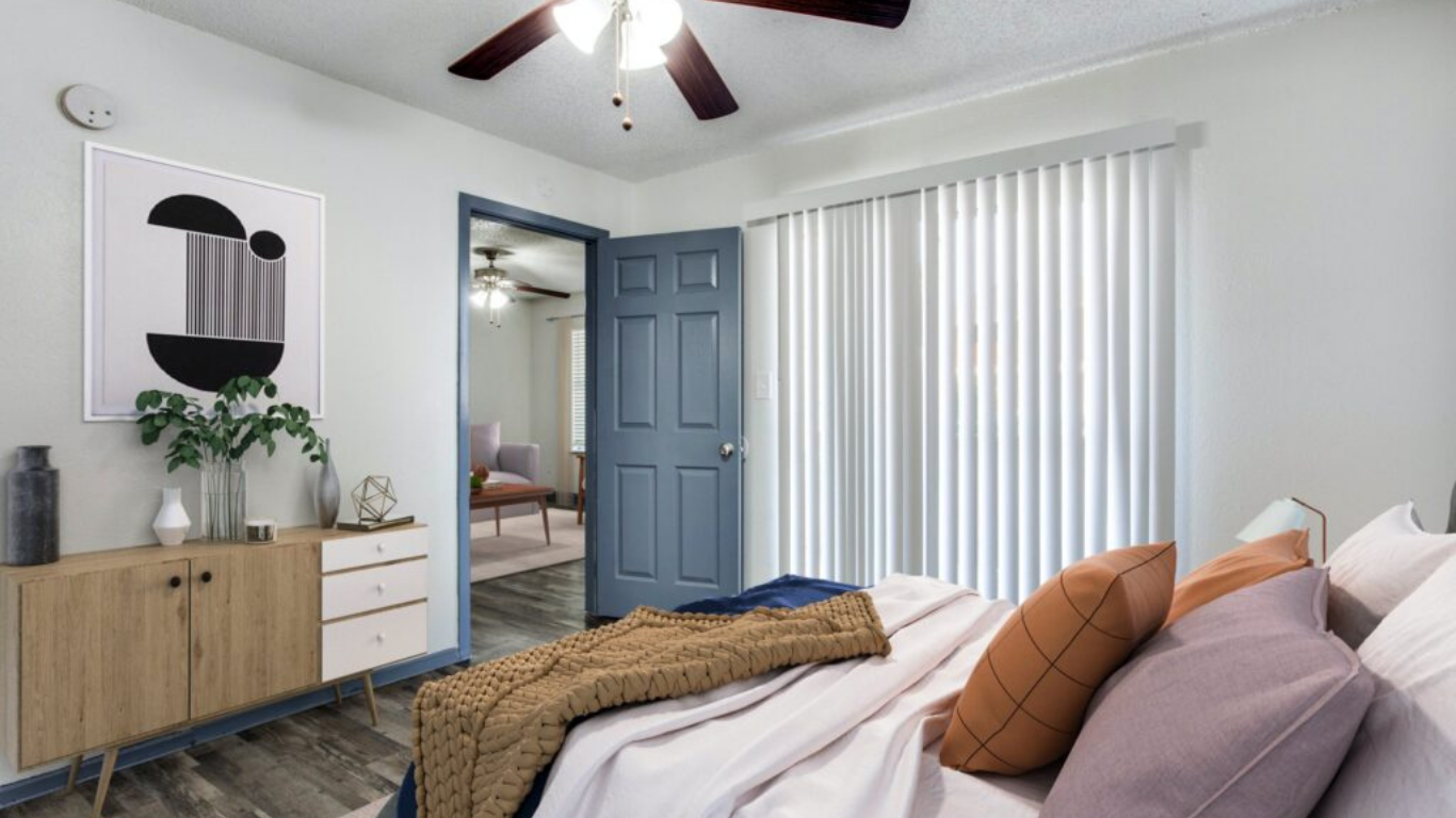 a bedroom with a ceiling fan and a bed at The Meadows on Merrill