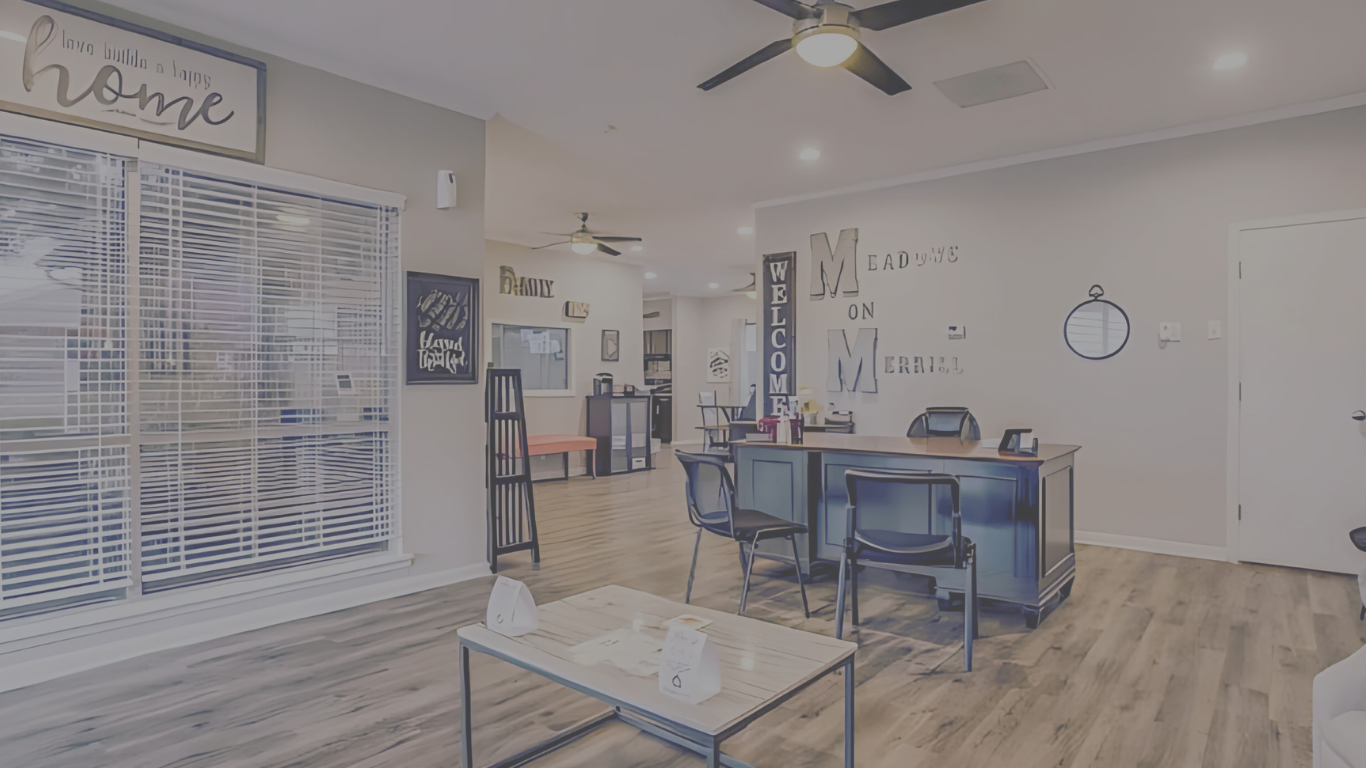 a living room with a ceiling fan and a table at The Meadows on Merrill