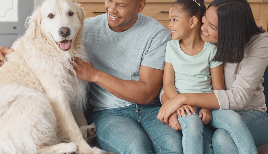 a family sitting on a couch with a dog at The Meadows on Merrill