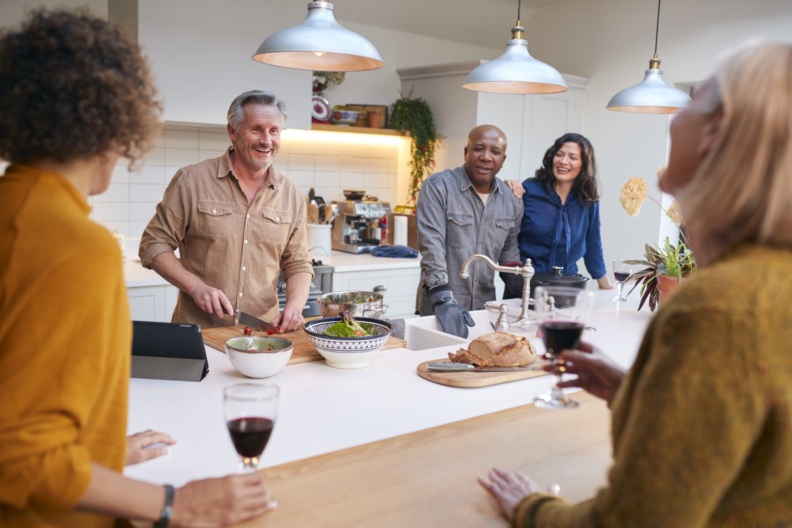 a group of people standing around a kitchen table at The Hudson Oaks