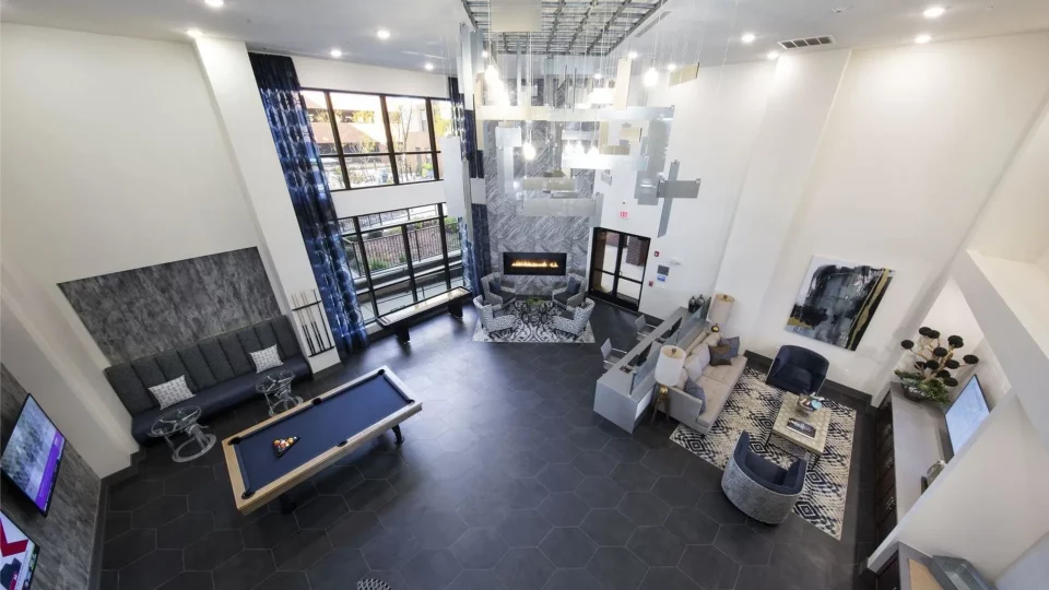 the living room has a pool table and a fireplace at The Steelyard Apartments