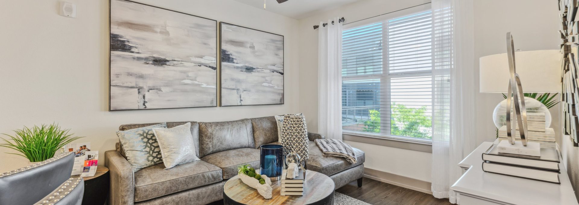 a living room with a ceiling fan and a couch at The Steelyard Apartments