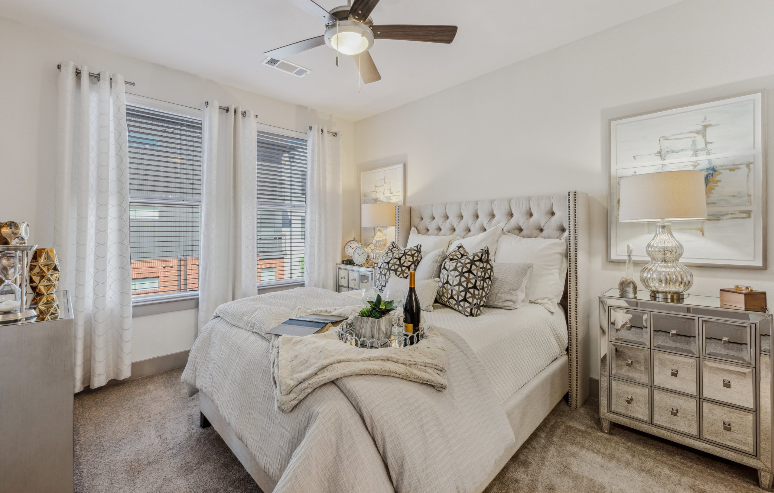 a bedroom with a bed, dresser and ceiling fan at The Steelyard Apartments