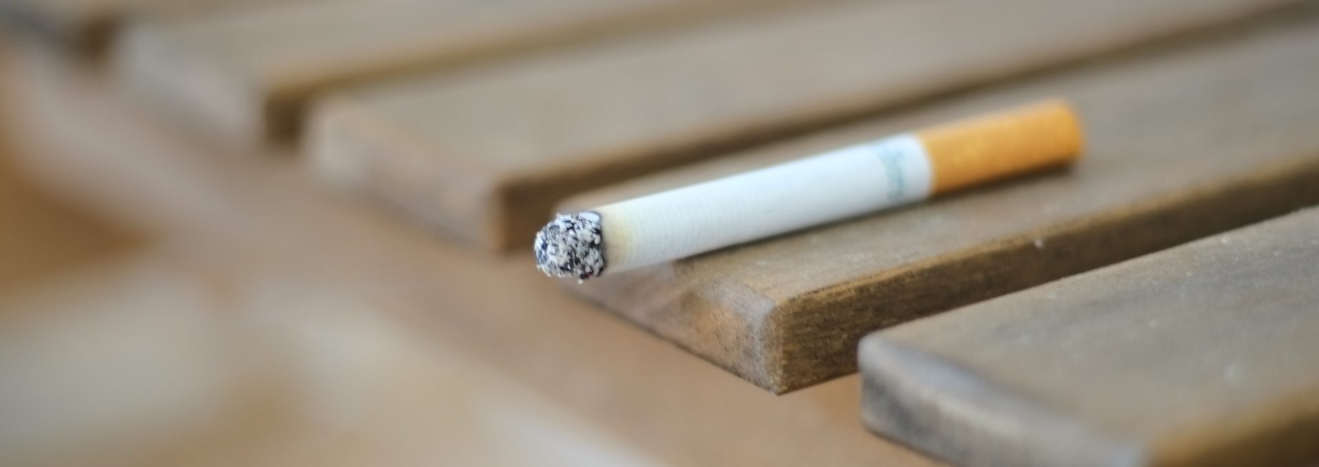 a cigarette sitting on top of a wooden bench