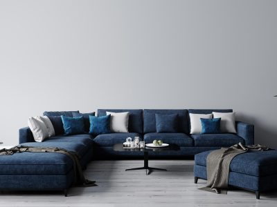 a blue sectional sofa with two ottomans and a coffee table at The Discovery Park Life Apartments