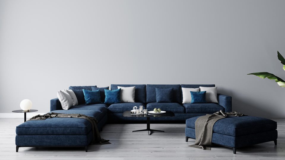 a blue sectional sofa with two ottomans and a coffee table at The Discovery Park Life Apartments