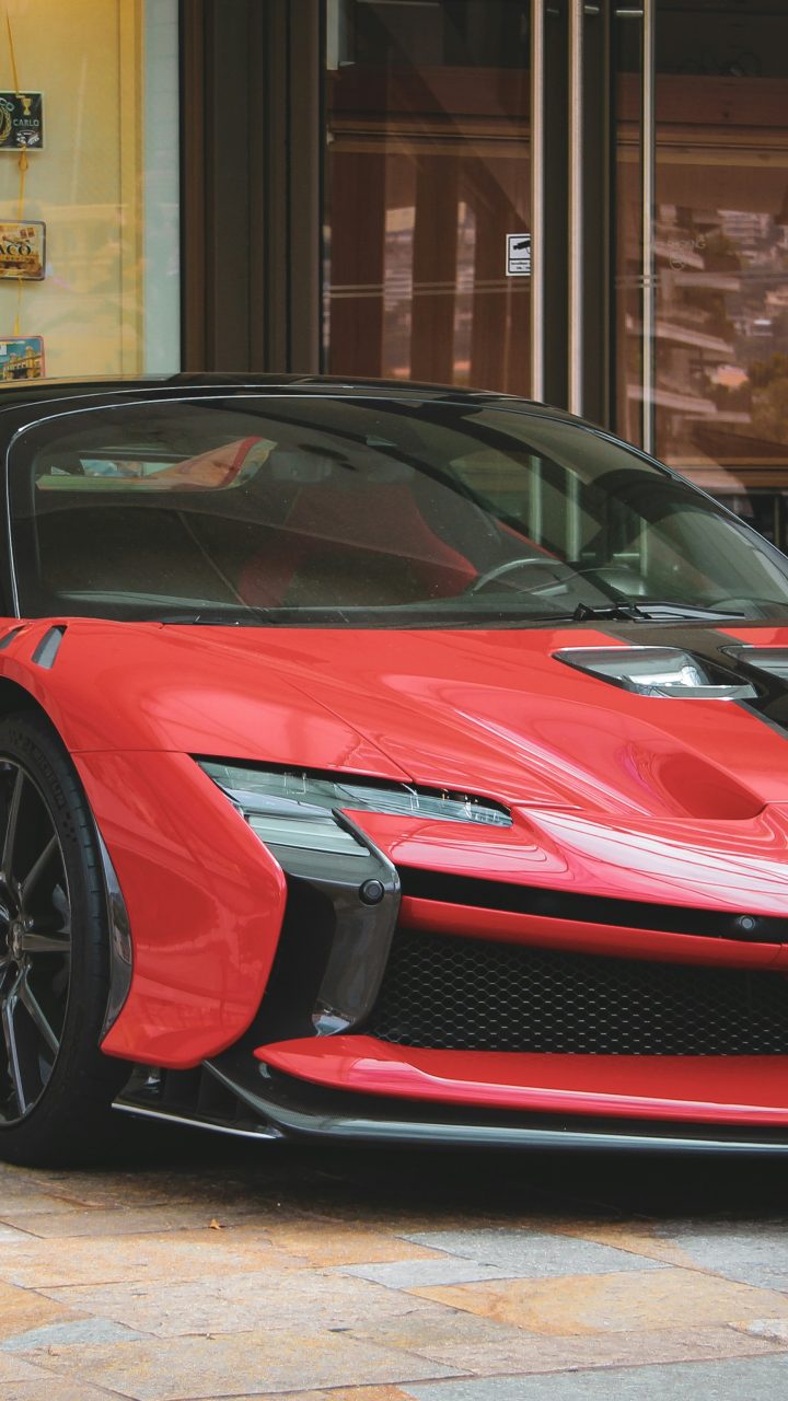 A red ferrari sports car with a black stripe.