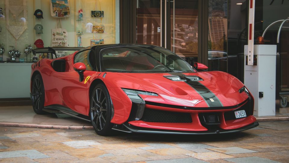 A red ferrari sports car with a black stripe.