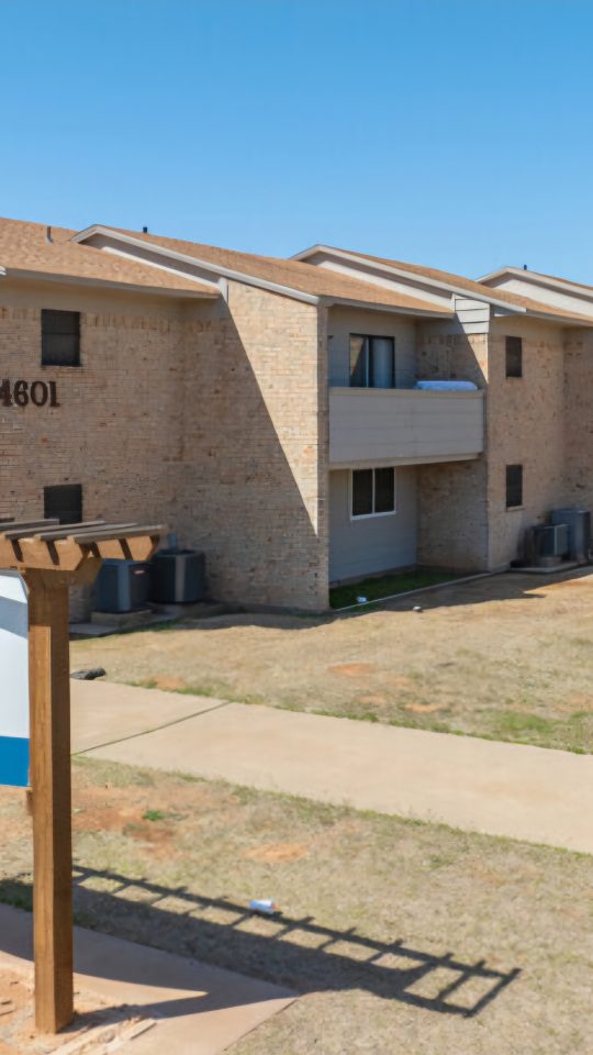 the sign for the apartment complex in front of a grassy area at The  Courtyard