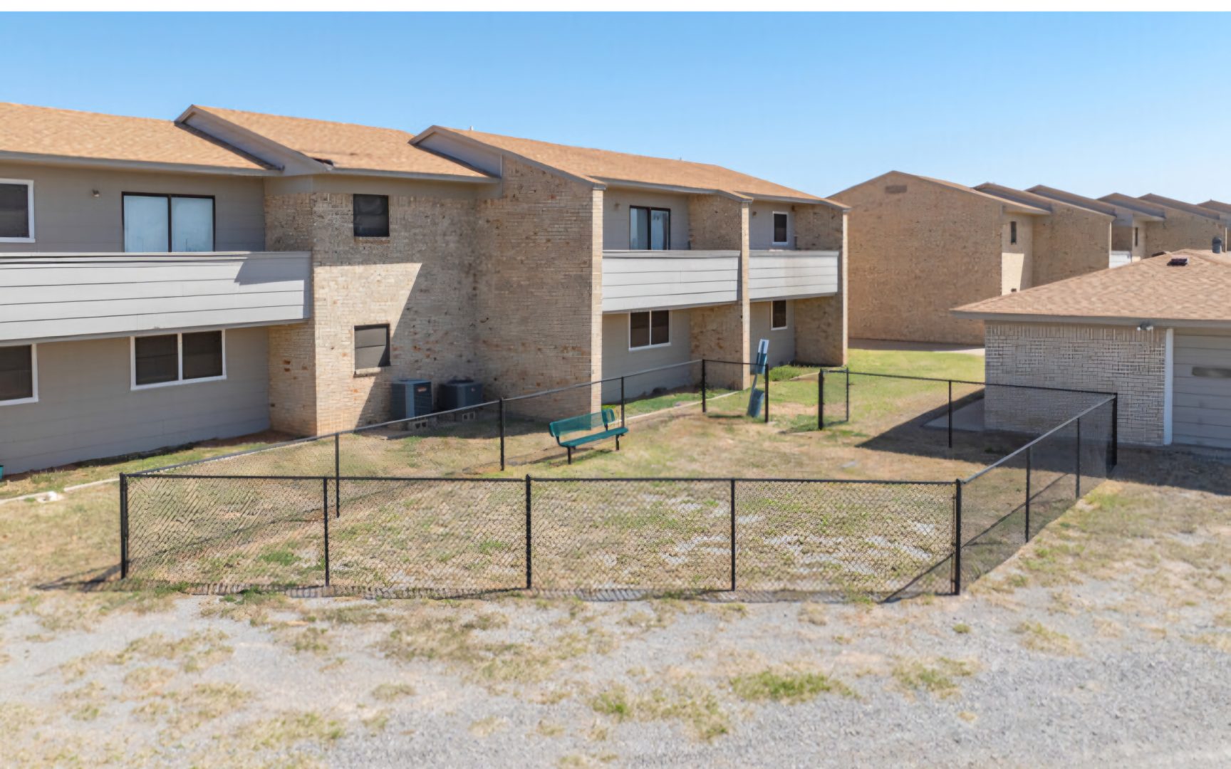 the apartment complex has a fenced in yard at The  Courtyard