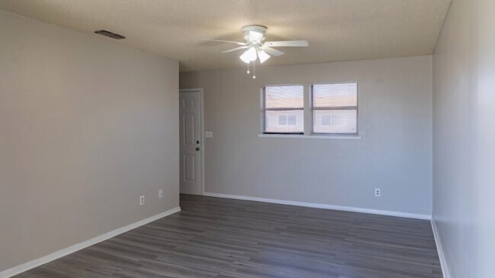 empty room with ceiling fan and hardwood floors at The  Courtyard