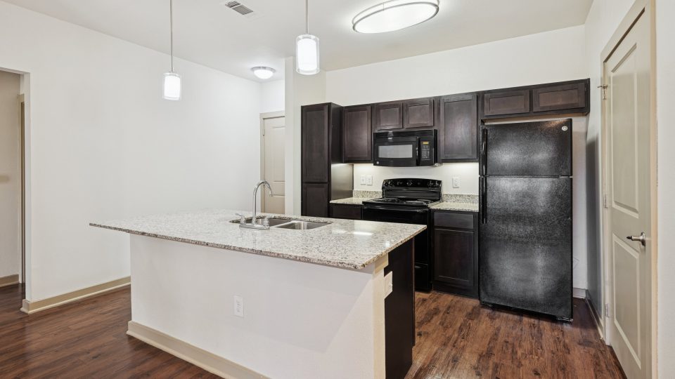 a kitchen with a refrigerator, stove, sink and a microwave