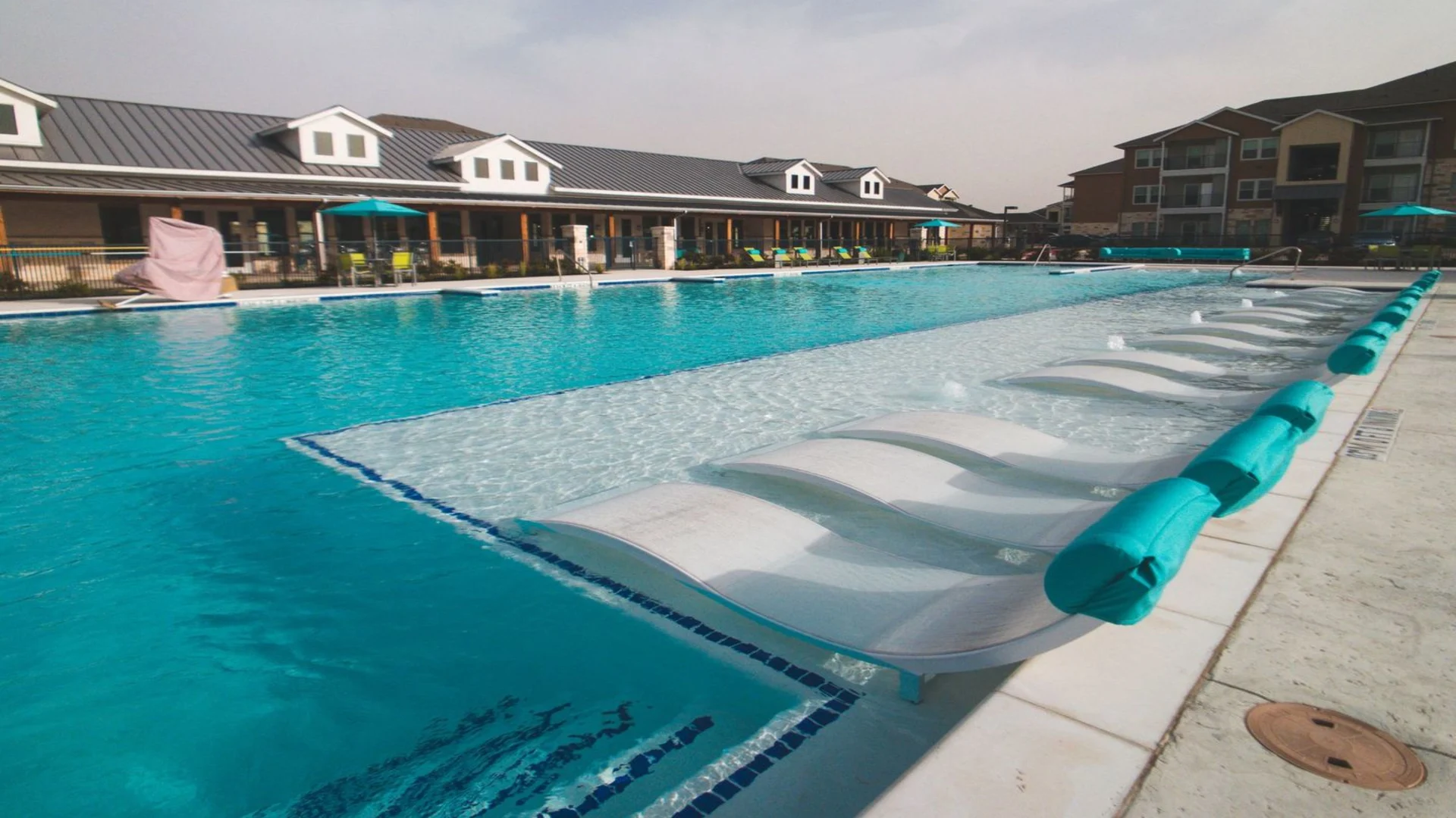 a large pool with lounge chairs and umbrellas at The Biltmore at Park