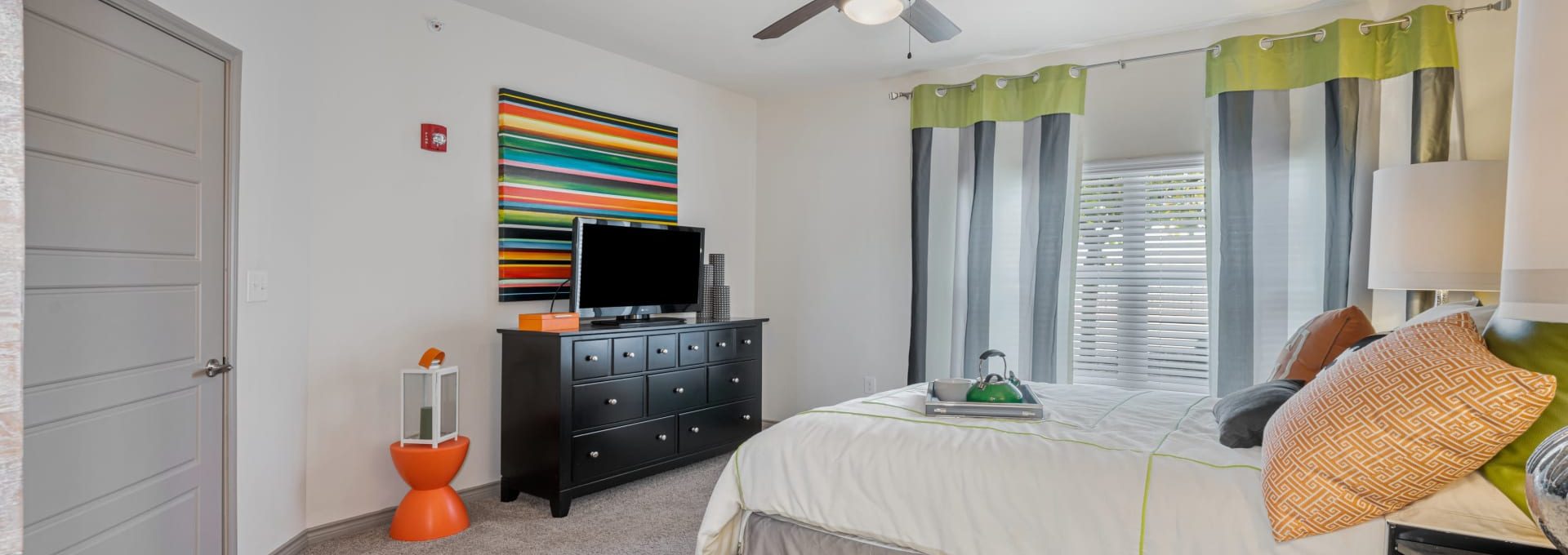 a bedroom with a bed, dresser, and television at The  BLVD