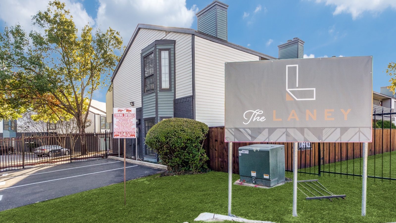 the sign for the apartment complex is in front of a grassy area at The Laney