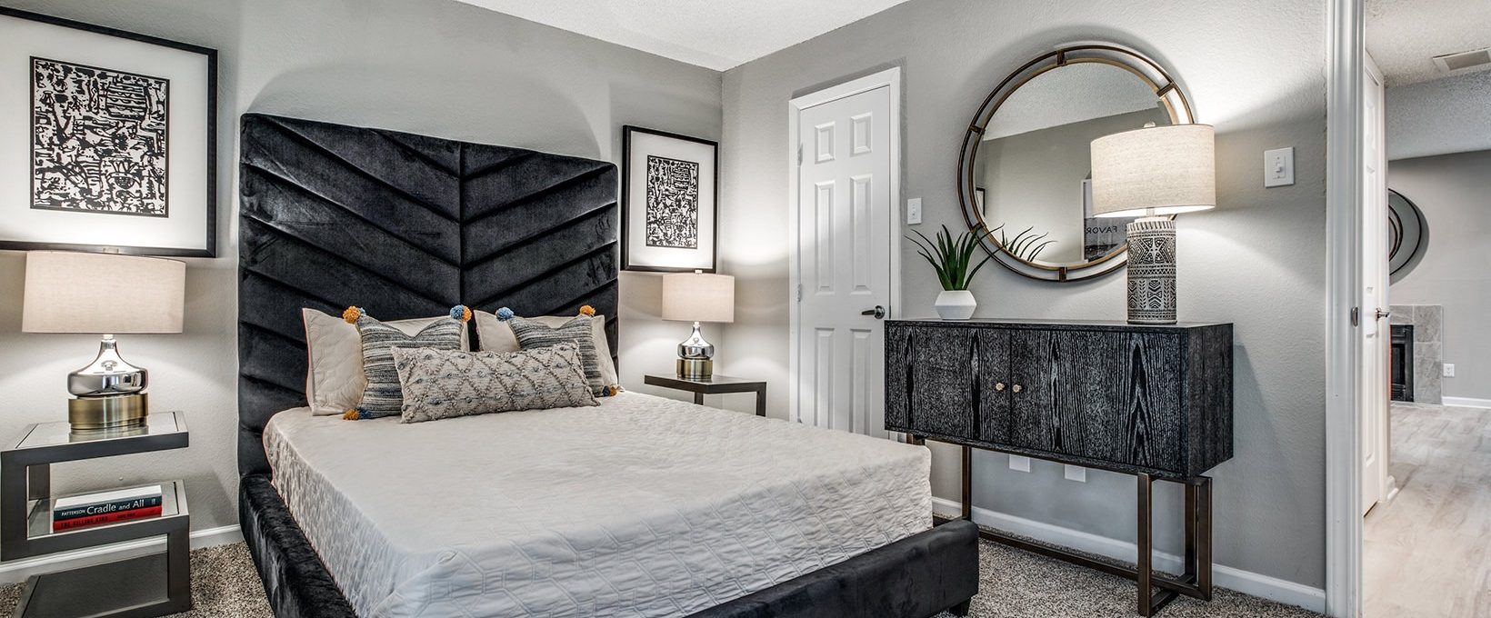 a bedroom with a black bed and a mirror at The  Laney