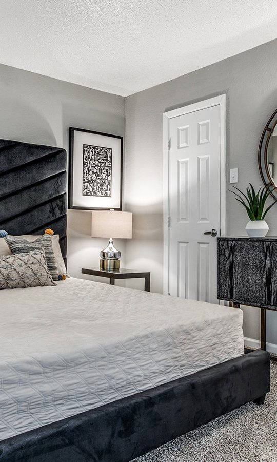 a bedroom with a black bed and a mirror at The  Laney