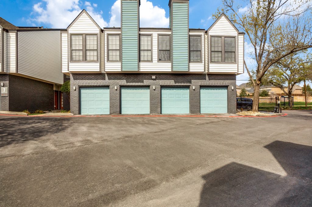 the parking lot at a residential complex with two garages at The  Laney