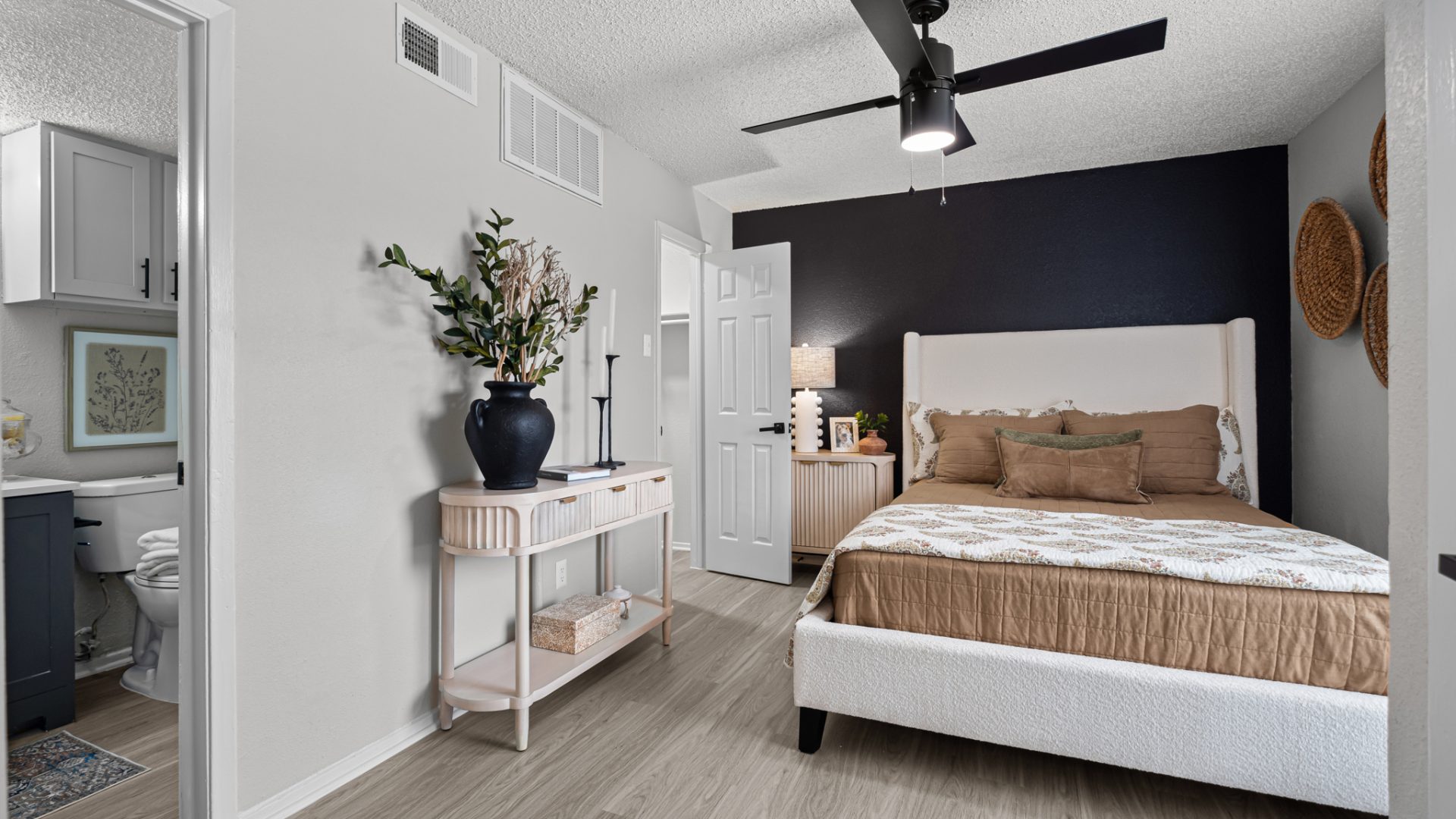 a bedroom with a ceiling fan and hardwood floors at The Dahlia