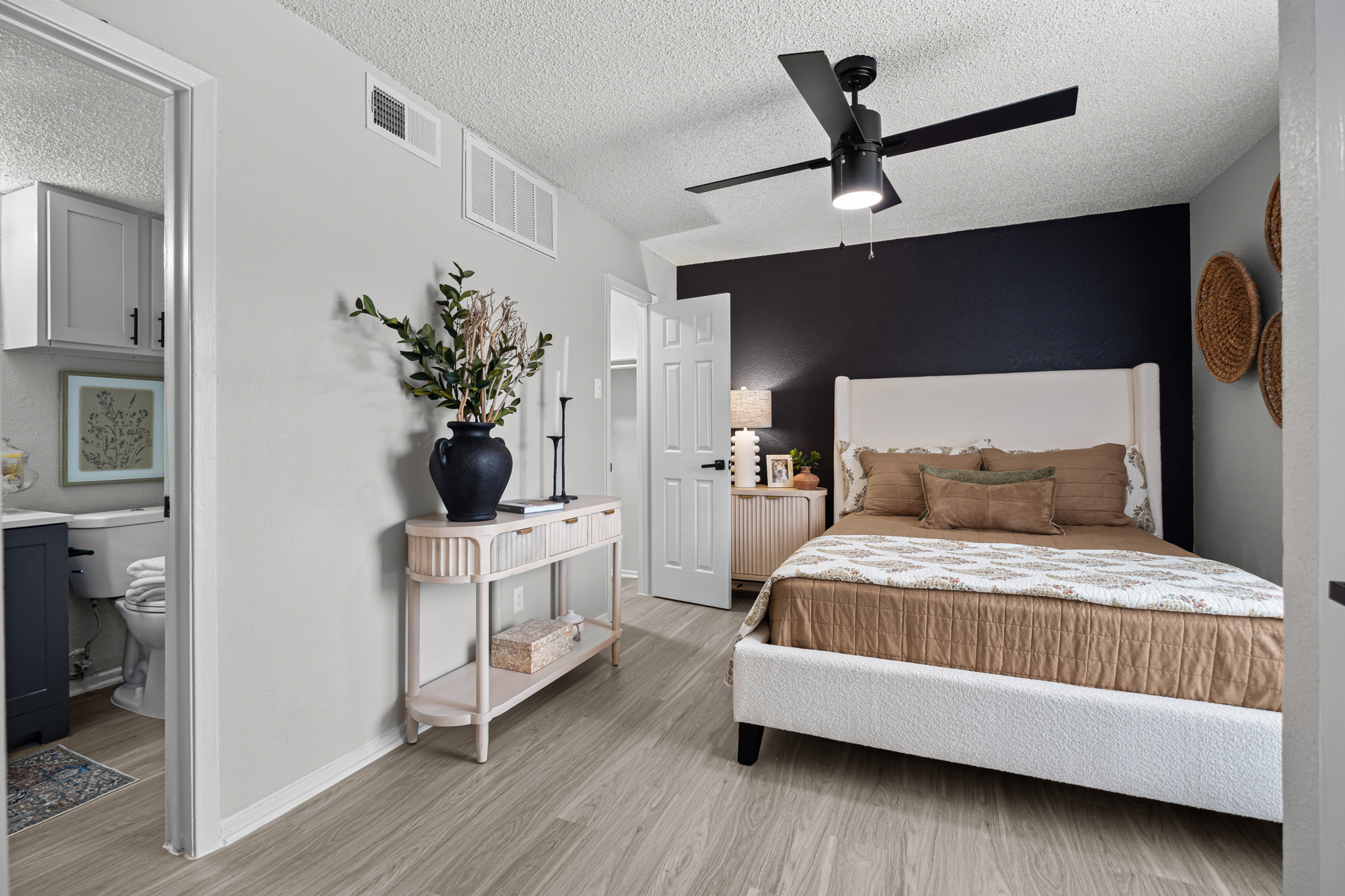 a bedroom with a ceiling fan and hardwood floors at The Dahlia