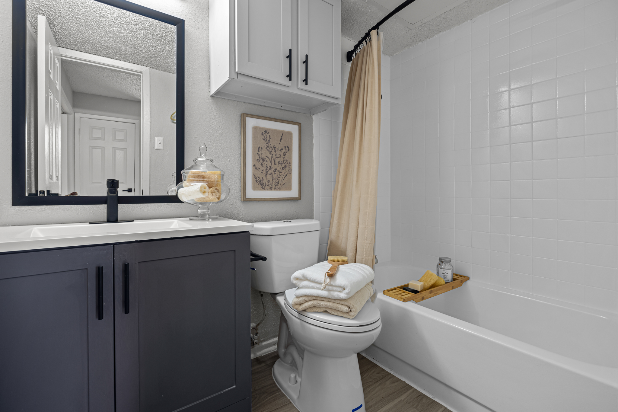 a bathroom with a white toilet, tub and sink at The Dahlia