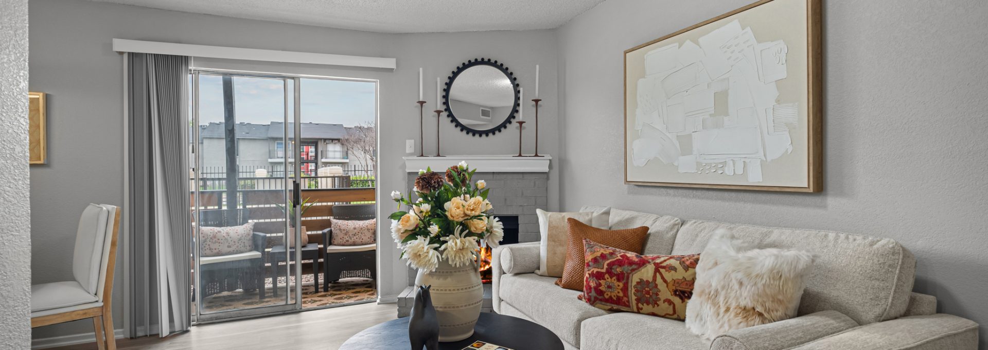 a living room with a couch, coffee table and a sliding glass door at The  Dahlia