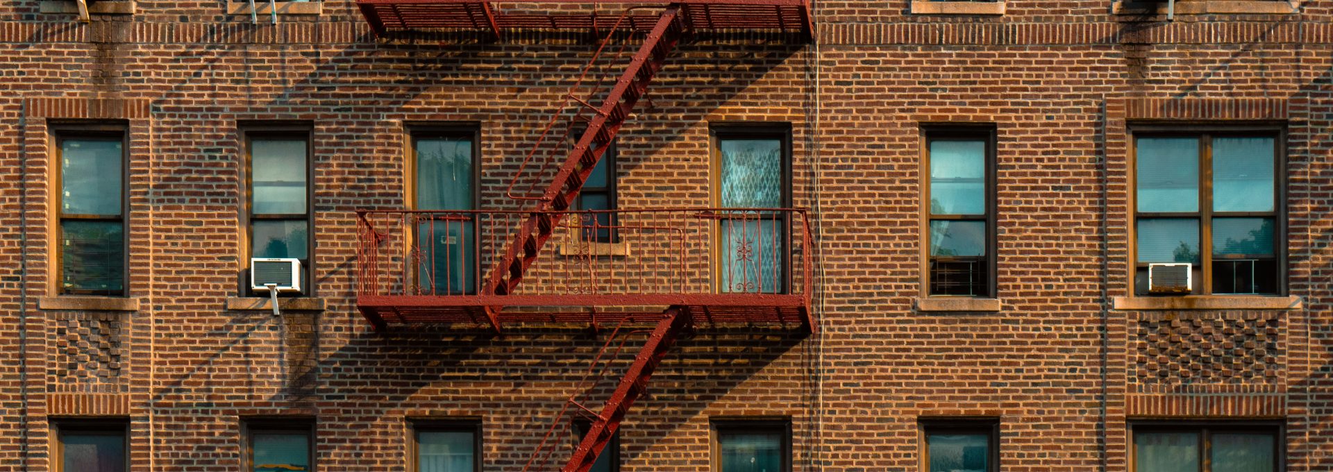 A tall brick building with a fire escape