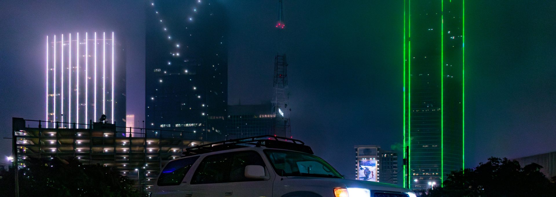 a white suv parked in front of a tall building