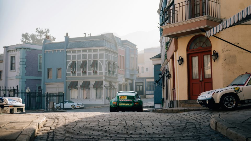 A car is parked on a cobblestone street