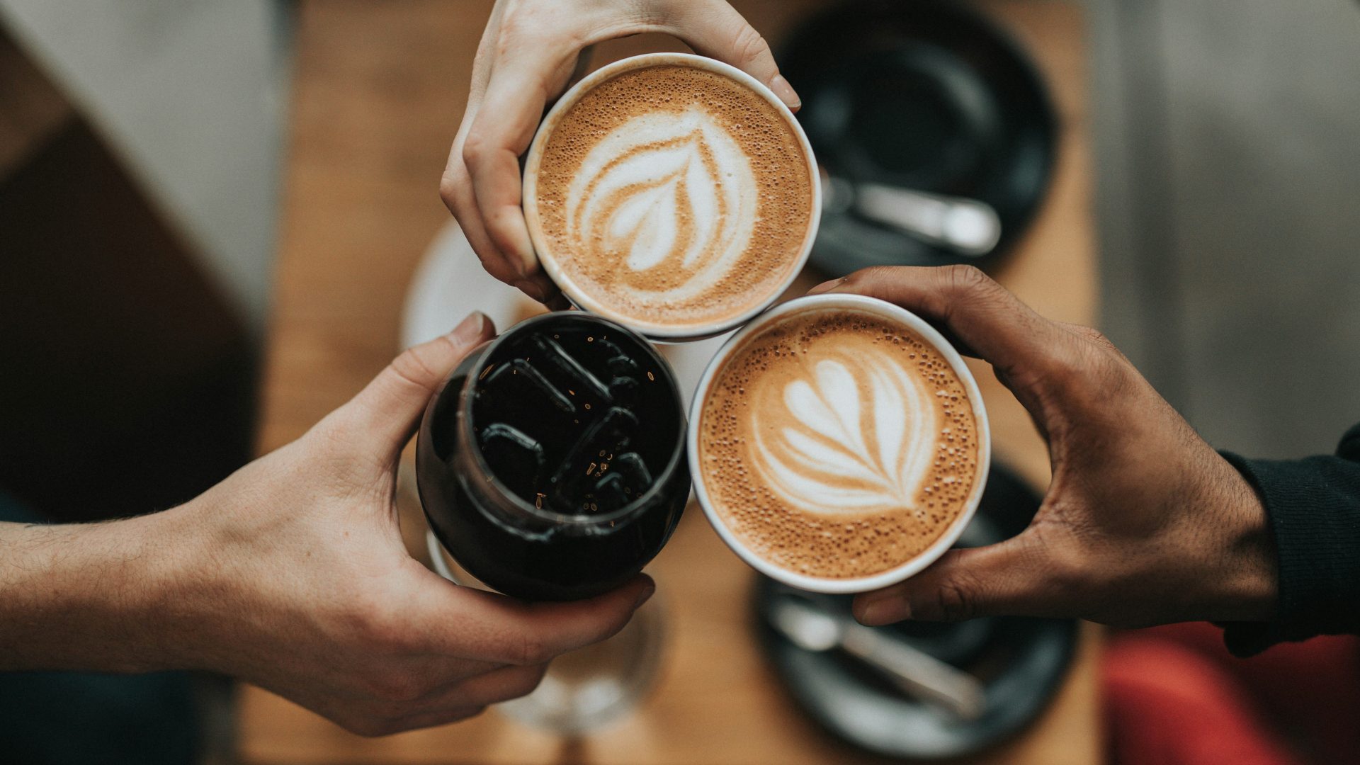 three person holding beverage cups