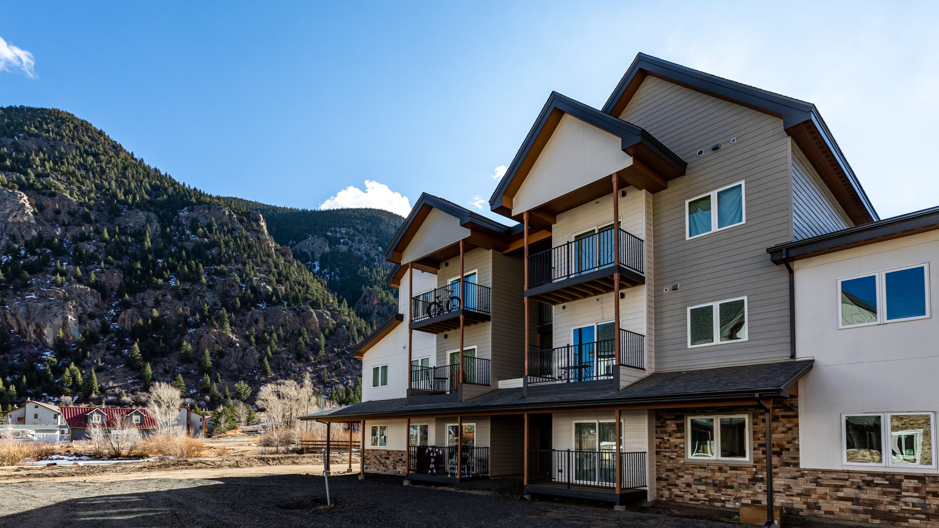 the exterior of a two story apartment building with mountains in the background at The Bighorn Crossing