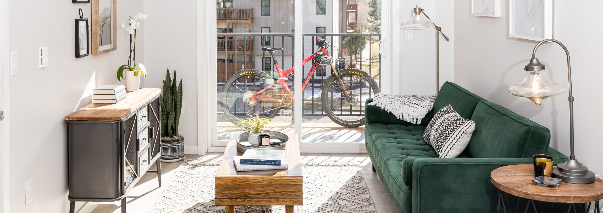 a living room with a green couch and a sliding glass door at The Bighorn Crossing