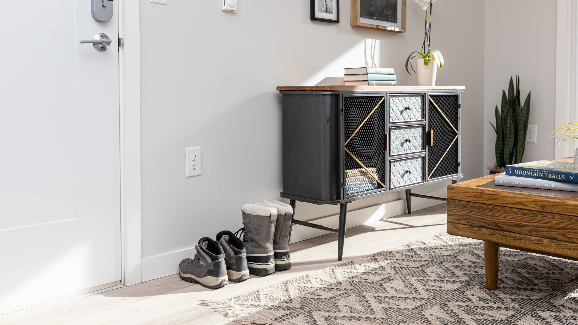 a living room with a rug, coffee table, and a door at The Bighorn Crossing