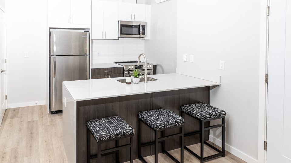 a kitchen with a stainless steel sink and bar stools at The Bighorn Crossing