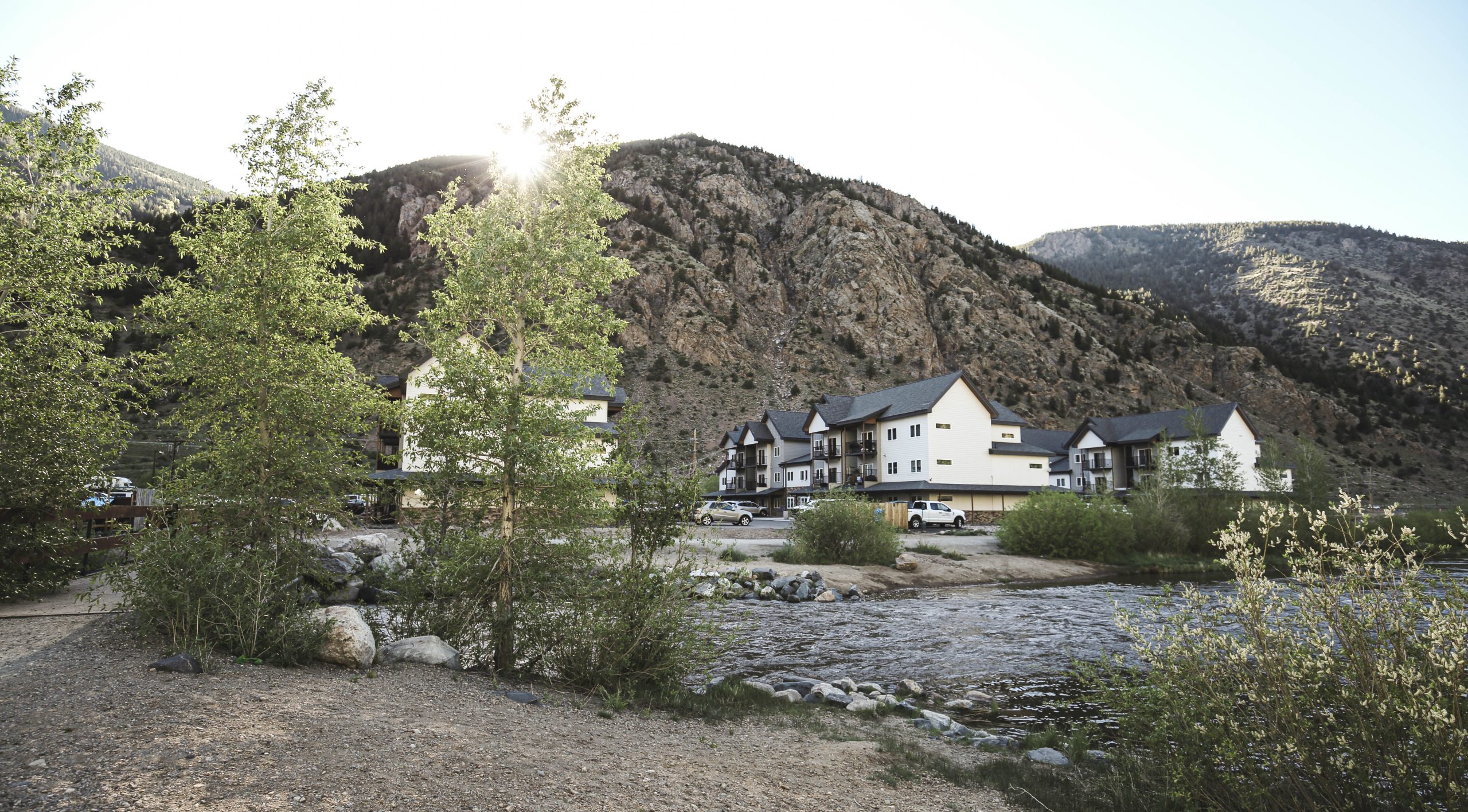 a river runs through a mountain town with houses at The Bighorn Crossing