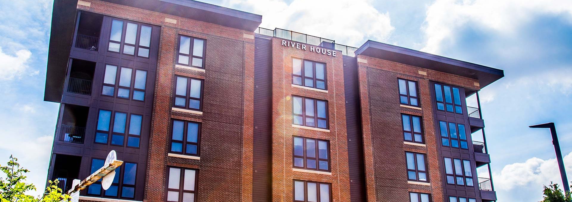 a large brick building with windows and a blue sky at The River House